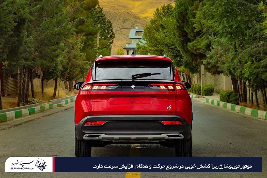 اتومبیل ریرا قرمزرنگ از نمای پشت با چراغهای روشن در جاده