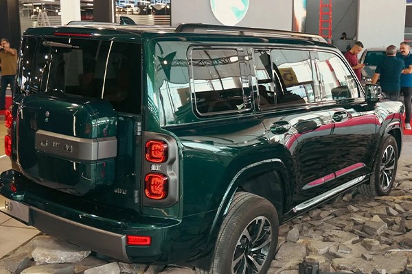هاوال H9 سبز رنگ با چراغ‌های قرمز از نمای پشت در نمایشگاه