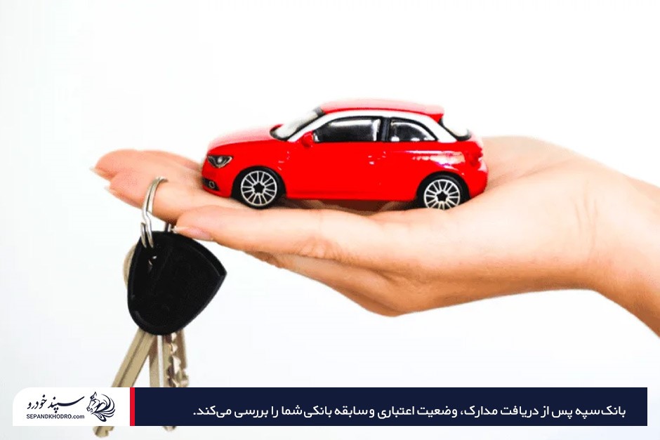 ماشین کوچک قرمز اسباببازی به همراه سوییچ در درست یک انسان