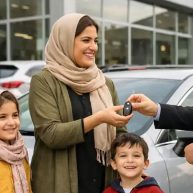 یک مادر همراه با سه فرزند در حال تحویل گرفتن سوییچ ماشین در کنار خودرو