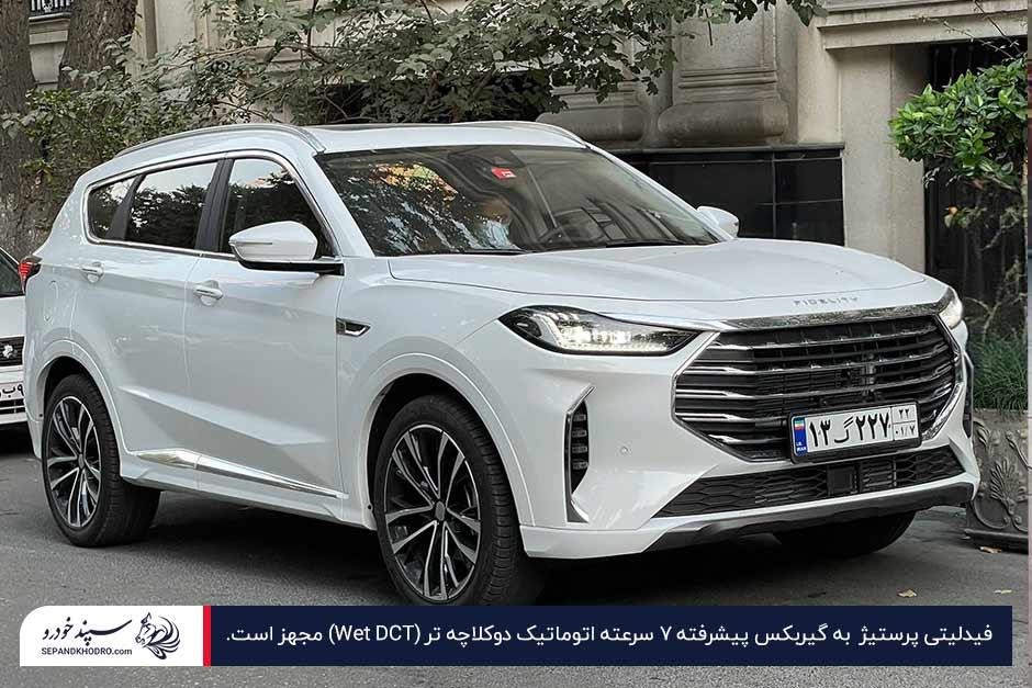عکس نمای جلو فیدلیتی الیت سفید با چراغهای روشن و جلوپنجره بزرگ، پارکشده در نمایشگاه