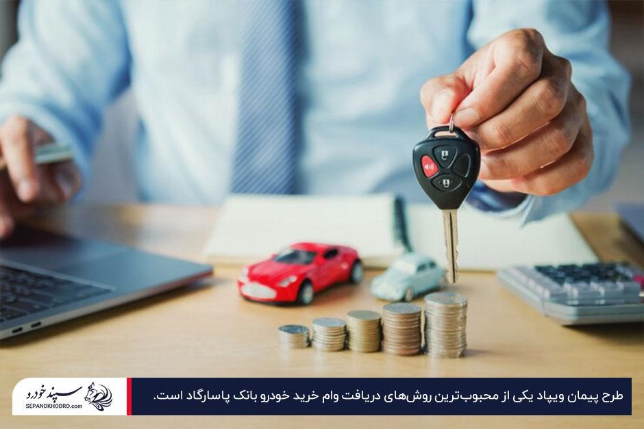فردی در حال نشان دادن سوییچ خودرو در کنار سکههای روی میز و ماشین اسباببازی قرمز